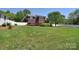 Spacious backyard with brick home, white fence, large shade tree and lush green lawn at 16610 Blackberry Hills Dr, Midland, NC 28107