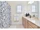 Bright bathroom showcasing a vanity with double sinks, a floral shower curtain, and natural lighting at 16610 Blackberry Hills Dr, Midland, NC 28107