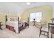 Bright bedroom with a four-poster bed, sitting area and warm yellow walls at 16610 Blackberry Hills Dr, Midland, NC 28107