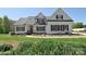 Charming white two-story home featuring a red front door, black shutters, and a well-manicured lawn at 16610 Blackberry Hills Dr, Midland, NC 28107