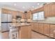Bright kitchen with island, stainless appliances, bar stool seating, and natural wood cabinets at 16610 Blackberry Hills Dr, Midland, NC 28107