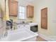 Bright laundry room with sink, washer, dryer, window and storage cabinets at 16610 Blackberry Hills Dr, Midland, NC 28107