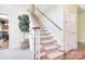 Carpeted staircase with wood handrail and white trim, enhanced by a decorative tree at 16610 Blackberry Hills Dr, Midland, NC 28107