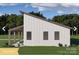 Modern farmhouse showcasing clean lines, sleek roof, inviting covered patio area, and lush green lawn at 180 Nc 742 Hwy, Wadesboro, NC 28170