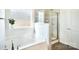 Bright bathroom showcasing a soaking tub beneath a window and a separate shower with glass enclosure at 221 Mountain Island Dr, Statesville, NC 28677