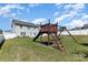 Spacious backyard with play set, lush green grass, mature trees and a privacy fence at 2220 Atwell Glen Ln, Pineville, NC 28134
