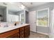Well-lit bathroom featuring a double sink vanity, a large mirror, and a window, offering a functional and bright space at 2220 Atwell Glen Ln, Pineville, NC 28134