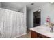 Bright bathroom featuring a shower with a patterned curtain and a dual sink vanity, with direct access to the walk-in closet at 2220 Atwell Glen Ln, Pineville, NC 28134