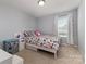 Light-filled bedroom with vibrant floral bedding, featuring neutral-toned walls and a cozy atmosphere, ideal for relaxation at 2220 Atwell Glen Ln, Pineville, NC 28134