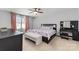 This bedroom offers ample natural light, creating a serene atmosphere complemented by a plush bench at the foot of the bed at 2220 Atwell Glen Ln, Pineville, NC 28134