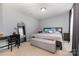 Comfortable bedroom featuring a desk, a mirror, and a cozy bed with neutral bedding, creating a serene retreat at 2220 Atwell Glen Ln, Pineville, NC 28134