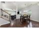 Elegant dining room with hardwood floors, modern lighting, and an open view to the living room at 2220 Atwell Glen Ln, Pineville, NC 28134