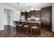 The kitchen island provides barstool seating, dark cabinetry, stainless steel appliances and granite countertops at 2220 Atwell Glen Ln, Pineville, NC 28134