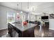 Open kitchen view to living room featuring a kitchen island with bar stool seating and pendant lighting at 2220 Atwell Glen Ln, Pineville, NC 28134