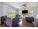 Bright living room featuring hardwood floors, modern furniture, and a large wall-mounted television at 2220 Atwell Glen Ln, Pineville, NC 28134