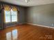 This bedroom features hardwood floors, a large window, and neutral color scheme at 2417 Lynwood Dr, Lancaster, SC 29720