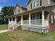 Charming home with a full covered porch, white railing, and green shutters on a sunny day at 2417 Lynwood Dr, Lancaster, SC 29720