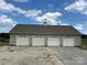 Spacious four-car garage with white doors and a decorative weather vane on a sunny day at 2417 Lynwood Dr, Lancaster, SC 29720