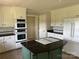 Well-equipped kitchen featuring white cabinets, stainless steel appliances, a green island and tiled flooring at 2417 Lynwood Dr, Lancaster, SC 29720