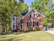 Charming two-story brick home with a well-manicured lawn and lush landscaping, offering classic curb appeal at 2805 Bathgate Ln, Matthews, NC 28105