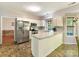 Well-lit kitchen with white cabinets, stainless steel appliances, and a breakfast bar, creating a functional space at 2805 Bathgate Ln, Matthews, NC 28105