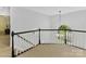 Second story landing with black railing and window overlooking the front yard provides natural light to this home at 2805 Bathgate Ln, Matthews, NC 28105