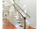 View of carpeted staircase with black handrail, hardwood floors, and entry to kitchen creating an inviting transition at 2805 Bathgate Ln, Matthews, NC 28105