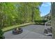 Large backyard patio with a stone fire pit surrounded by lush trees at 3060 Drummond Ave, Indian Land, SC 29707