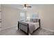 Relaxing bedroom features a ceiling fan, large window, and neutral decor at 3060 Drummond Ave, Indian Land, SC 29707