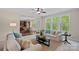 Bright living room features neutral decor, a ceiling fan, and backyard views through large windows at 3060 Drummond Ave, Indian Land, SC 29707