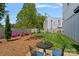 Charming backyard featuring a patio set, green lawn, and a privacy fence with flowering shrubs at 310 Wesley Heights Way, Charlotte, NC 28208