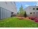 Beautiful backyard with lush green grass, a wooden fence, and landscaping with colorful flowers at 310 Wesley Heights Way, Charlotte, NC 28208