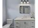 Bathroom featuring a white vanity with marble countertop, toilet, and modern mirror at 310 Wesley Heights Way, Charlotte, NC 28208
