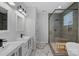 Modern bathroom features dual vanities, a glass-enclosed shower, and elegant marble flooring at 310 Wesley Heights Way, Charlotte, NC 28208