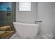 Bright bathroom featuring an elegant freestanding tub with marble flooring and tiled walk-in shower at 310 Wesley Heights Way, Charlotte, NC 28208