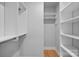 Walk-in closet featuring built-in shelves, hanging rods, and hardwood floors at 310 Wesley Heights Way, Charlotte, NC 28208
