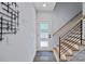 Inviting entryway featuring a modern door, staircase with wooden treads, and contemporary coat rack at 310 Wesley Heights Way, Charlotte, NC 28208