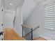 Hallway with wood floors and modern staircase with black metal railings and wood handrail at 310 Wesley Heights Way, Charlotte, NC 28208