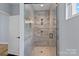 Modern shower featuring glass door, tiled walls, and rainfall shower head at 310 Wesley Heights Way, Charlotte, NC 28208