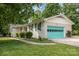 Charming white brick home with green shutters and a brightly colored turquoise garage door at 334 Hudson Dr, Harrisburg, NC 28075