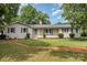 Charming one story brick home with a well-maintained lawn and inviting front porch at 334 Hudson Dr, Harrisburg, NC 28075