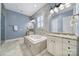 Well-lit bathroom with a soaking tub, tiled walls, granite countertops, and stylish fixtures at 374 Horton Grove Rd, Fort Mill, SC 29715