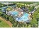 Aerial view of community pool with lap lanes, a lazy river, and lounging areas alongside tennis courts at 374 Horton Grove Rd, Fort Mill, SC 29715