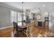Open kitchen and dining area featuring stainless appliances, island with wine storage, and hardwood flooring at 374 Horton Grove Rd, Fort Mill, SC 29715