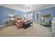 Bright main bedroom with light blue walls, a seating area, a walkout, and plantation shutters at 374 Horton Grove Rd, Fort Mill, SC 29715