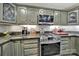 Close-up of a gourmet kitchen with stainless steel appliances, gray cabinets and tile backsplash at 4 Hummingbird Ct, Clover, SC 29710