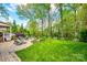 Landscaped backyard with patio, fire pit area, green lawn, and mature trees at 405 Five Leaf Ln, Waxhaw, NC 28173