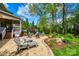 Backyard patio with stone pavers, fire pit, lounge chairs, and lush landscaping at 405 Five Leaf Ln, Waxhaw, NC 28173