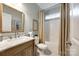 Bright bathroom with a marble countertop vanity, updated fixtures, and a shower-tub combination with a window at 405 Five Leaf Ln, Waxhaw, NC 28173