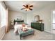 Relaxing bedroom features a ceiling fan, a large window, and charming green furniture at 405 Five Leaf Ln, Waxhaw, NC 28173